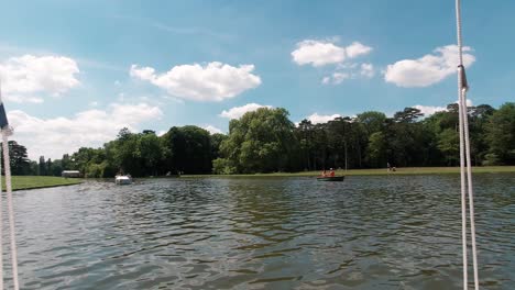 POV-Ansicht-Vom-Boot-Aus,-Das-An-Einem-Hellen-Und-Sonnigen-Tag-Auf-Einem-Wunderschönen-See-Schwimmt,-Während-Sich-Weitere-Boote-Nähern