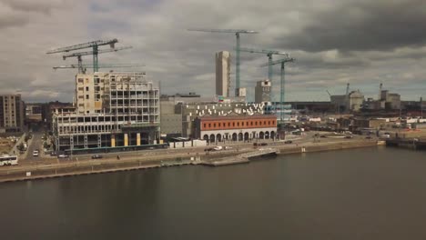 Overlooking-the-tree-Arena-in-the-Republic-Of-Ireland,-this-image-is-a-drone-panning-to-the-right-shot-with-the-East-Link-Bridge-Port-and-some-traffic