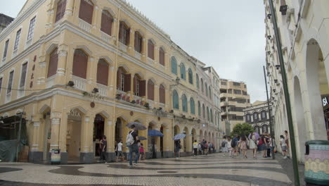 Lapso-De-Tiempo-De-La-Plaza-Del-Senado-Con-Edificios-Pintados-De-Colores-Y-Turistas-Que-Pasan-En-Un-Día-Nublado-En-Macao,-Sar-De-Macao,-China