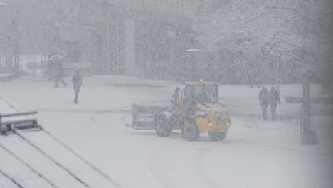 A-wheel-loader-driving-backwards-on-a-snow-covered-plaza