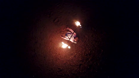 Aerial-Drone-Shot-of-Man-Fire-Dancing-on-Brighton-Beach