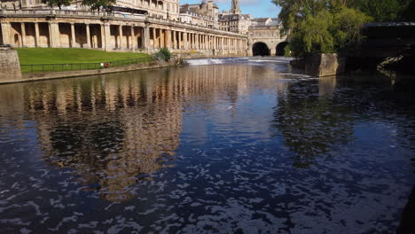 Empire-Hotel,-Pulteney-Weir---Pulteney-Bridge-En-Bath,-Somerset-En-Una-Hermosa-Mañana-De-Verano-Desvaneciéndose-Hacia-El-Río-Avon