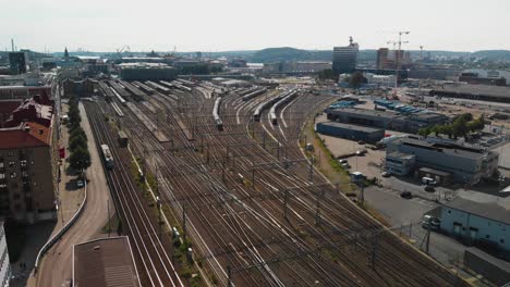 Vista-Aérea-Sobre-Los-Rieles-Que-Van-A-La-Estación-Central-De-Gotemburgo-Con-Trenes-Y-Tranvías