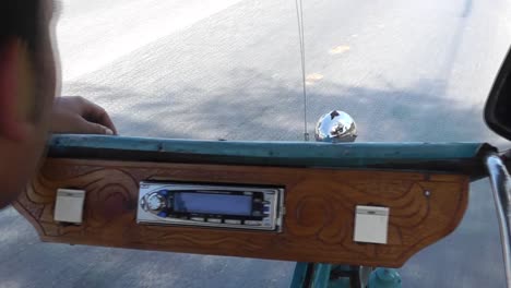 Close-up-view-from-the-backseat-of-a-traditional-Cuban-Rickshaw-Taxi-equipped-with-radio