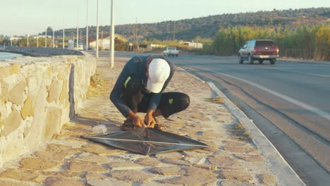 Joven-Refugiado-Afgano-Hace-Una-Cometa-Improvisada-Al-Aire-Libre-Junto-Al-Mar-En-Lesbos