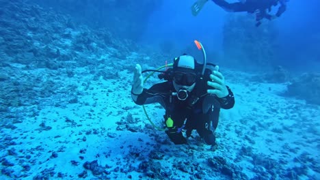 Diver-underwater-reaching-out-his-hand-to-the-camera