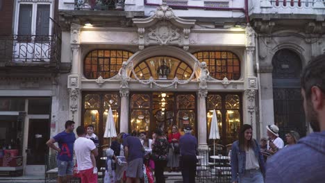 Majestätische-Caféfassade-In-Einer-Ruhigen-Nacht-Mit-Menschen,-Die-In-Der-Schlange-Stehen