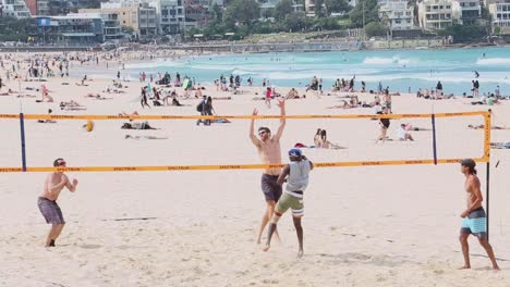 A-group-of-four-friends-playing-a-game-of-beach-volleyball-on-a-spring-day-at-Bondi-Beach-Sydney-Australia