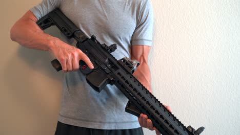 Man-holding-assault-rifle-and-adjusting-his-grip-and-inspecting-the-rifle