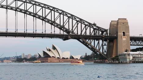 Blick-Auf-Sydney-Harbour-Bridge-Und-Sydney-Opera-House-In-Perfektem-Licht-Am-Späten-Nachmittag-Mit-Bootsverkehr-Auf-Dem-Wasser