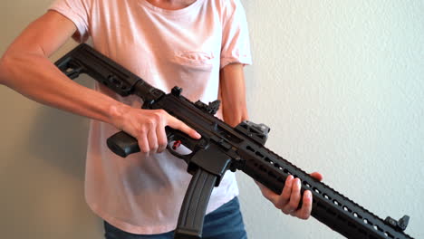 Woman-inspecting-her-new-assault-rifle-and-showing-it-from-different-angles