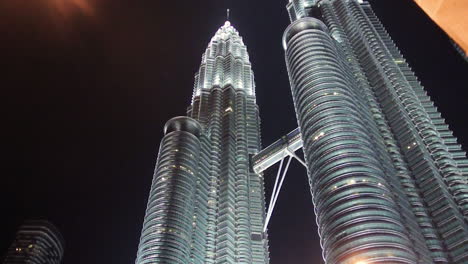 Vista-Panorámica-De-Las-Torres-Gemelas-Petronas-De-Singapur-A-Una-Calle-Concurrida-En-La-Noche