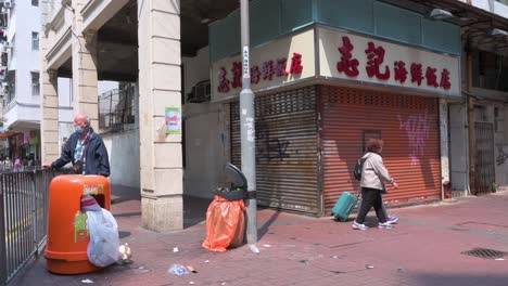 Fußgänger-Gehen-An-Einem-Geschlossenen-Geschäft,-Einem-Restaurant,-In-Hongkong-Vorbei