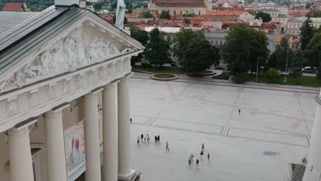 Toma-Aerea-De-Las-Columnas-Principales-De-La-Catedral-De-Vilna,-Con-Turistas-En-El-Suelo