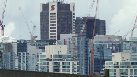 Expo-Line-SkyTrain-Passing-By-Downtown-Vancouver-With-Tower-Crane-Machine-In-British-Columbia,-Canada