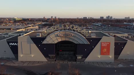 Flyover-of-Cineplex-Odeon-movie-theatre-cinema-exterior-with-signage-and-vacant-parking-lot