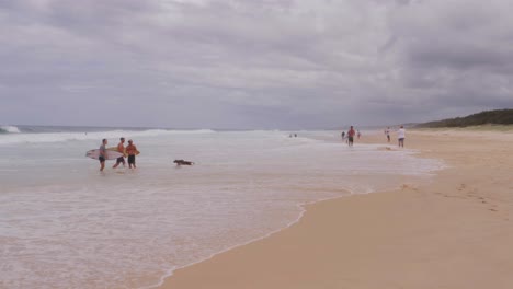 Gente-Salpicando-Las-Olas-Del-Mar-De-La-Playa-De-South-Gorge-En-Point-Lookout,-North-Stradbroke-Island,-Queensland,-Australia