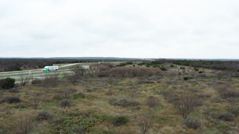 American-style-highway-surrounded-by-vast-wasteland-in-aerial-view