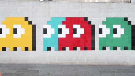 Los-Peatones-Pasan-Frente-A-Un-Arte-De-Wall-Street-Que-Representa-El-Clásico-Juego-De-Arcade-Pac-man-En-Hong-Kong