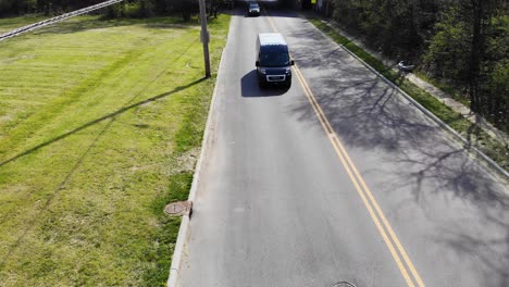 Amazon-lieferwagen-Fahren-Durch-Eine-Stadtstraße,-Aufgenommen-Von-Einer-Luftdrohne