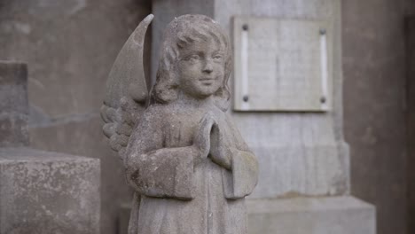 Kleiner-Süßer-Steinengel,-Der-Vor-Dem-Grabstein-Auf-Dem-Friedhof-Betet