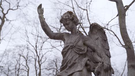 Very-Old-and-Ancient-Statue-of-Angel-Covered-with-Moss-Overlooking-Old-Graveyard-in-Uzupis