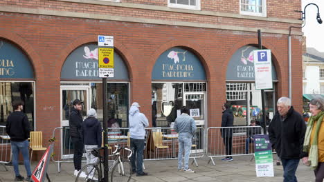 A-line-of-people-queueing-for-a-barbers-after-lockdown-restrictions-have-been-eased-in-UK