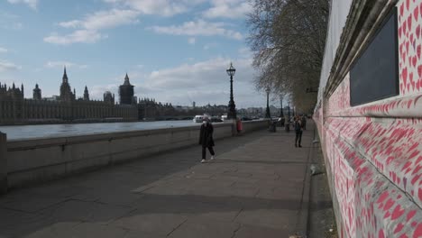 Wide-shot-of-National-Covid-memorial-wall-London-and-house-of-parliament-government-building