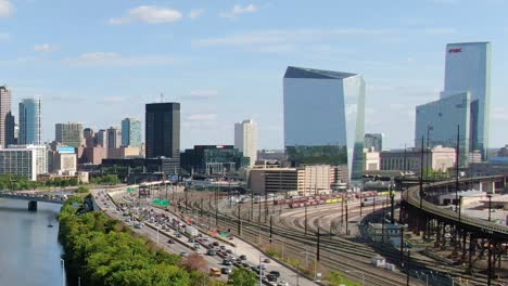 Philadelphia-skyline-with-highway-and-railways,-30th-street-train-station,-and-skyscrapers-with-business-offices-in-the-back