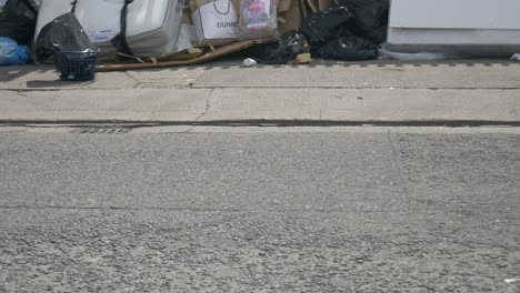 Pile-Of-Rubbish-Dumped-On-The-Empty-Street-With-Sign-Boards-Display-In-Fence-At-Dublin,-Ireland