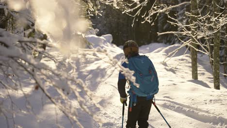 Slow-motion-skier-sliding-through-snow-forest-and-jumping