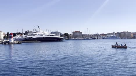 Traditional-way-to-transport-citizens-over-city-cove-with-a-boat-and-a-man-rowing