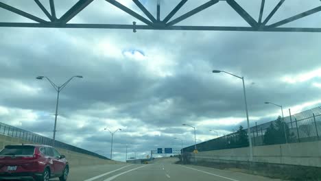 Domestic-and-international-arrivals-and-departures-signboards-on-road-while-driving-towards-a-Detroit-wayne-county-DTW-airport-mcnamara-terminal