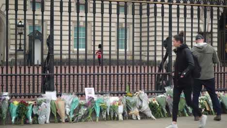 Blumen-Werden-Zu-Ehren-Von-Price-Philip-Niedergelegt,-Während-Ein-Wachmann-Im-Buckingham-Palace-Patrouilliert