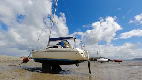 Schnell-Wechselndes-Wetter-über-Einem-Einzelnen-Festgemachten-Fischerboot-An-Der-Küste-Bei-Ebbe,-Sonnige-Bedingungen