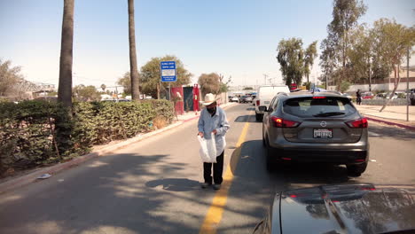 Viejo-Mendigo-Parado-En-Medio-De-La-Calle-En-Medio-Del-Peligro-Y-El-Tráfico-En-El-Cruce-Fronterizo-En-Tijuana,-México