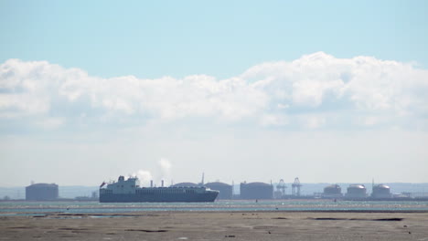 Lapso-De-Tiempo-De-Un-Buque-De-Carga-Que-Pasa-Por-Una-Refinería-De-Petróleo-Y-Gas-En-El-Estuario-Del-Támesis-Cerca-De-Leigh-on-sea-En-Un-Caluroso-Y-Soleado-Día-De-Primavera