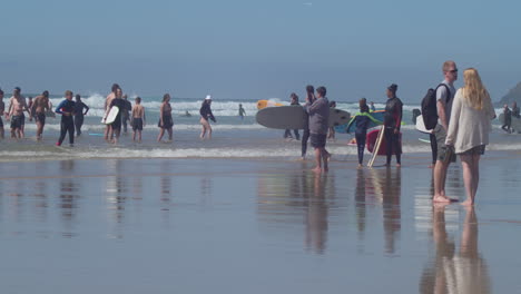 Turistas-Y-Surfistas-En-La-Concurrida-Playa-De-Perranporth-En-Un-Día-Soleado-En-Cornualles,-Inglaterra