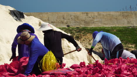 Cerca-De-Trabajadores-Al-Pie-De-Una-Montaña-De-Sal-Para-Llenar-Bolsas-Para-Minas-De-Sal