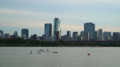 Paisaje-Urbano-Moderno-Con-Turistas-En-Kayak-Y-Remo-En-El-Río-Han,-Seúl,-Distrito-De-Gangnam,-Corea-Del-Sur