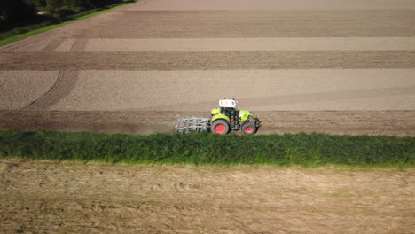 Vista-Aérea-Del-Campo-Agrícola-De-Labranza-Del-Tractor-Con-Grada,-4k