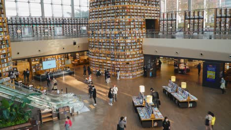 Menschen-Bewegen-Sich-Umher-Und-Schauen-Sich-Bücher-In-Der-Starfield-Bibliothek-Im-Coex-Einkaufszentrum-Im-Gangnam-Viertel,-Seoul-City,-Korea-An-–-Sie-Kippen-Nach-Unten,-Um-Eine-Zeitrafferaufnahme-Zu-Ermöglichen