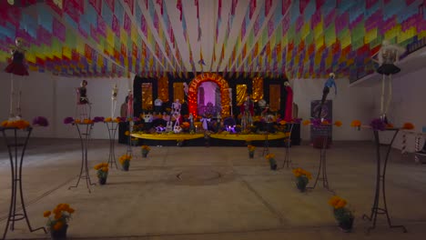 Altar-of-the-dead-created-for-the-celebration-of-the-day-of-the-dead-in-Mexico-Puebla-Cholula-adorned-with-flowers-skulls-candles-catrinas-and-food