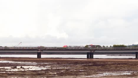 Una-Toma-De-Un-Autobús-Que-Cruza-El-Puente-Cinta-Costera,-Debajo-De-La-Arena-Y-El-Suelo-Del-Canal-De-Panamá-Mientras-El-Agua-Del-Océano-Se-Ha-Retraído-Durante-La-Marea-Baja,-Ciudad-De-Panamá