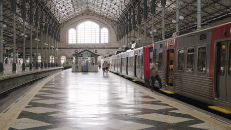 Pendler-Mit-Gesichtsmaske-Steigen-Am-Bahnhof-Rossio-Während-Der-Covid-19-Pandemie-In-Lissabon,-Portugal,-In-Den-Zug-Ein-Und-Aus