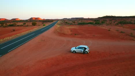 Umlaufende-Luftaufnahme-Eines-Autos-Am-Straßenrand-Des-Stuart-Highway-Bei-Sonnenaufgang---NT,-Australien