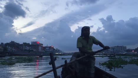 Silhouette-Eines-Bootsmannes,-Der-Sein-Landboot-Unter-Bewölktem-Himmel-Rudert