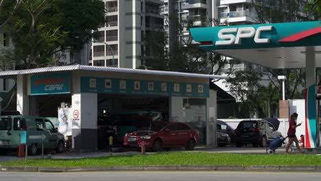 People-walking-by-Petrol-Station-from-SPC-in-Balestier,-Singapore