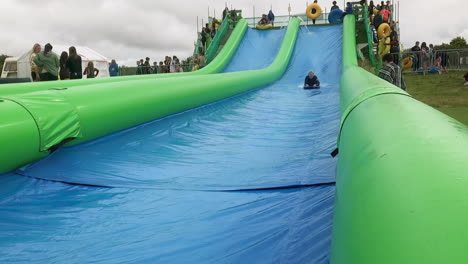 Engländerin-Rutscht-Auf-Einem-Brett-Bei-Giant-Slip-And-Slide-In-Cornwall,-Großbritannien