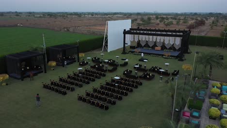 Ceremonia-De-Boda-Con-Vista-Aérea-Con-Un-Arco-Decorado-Con-Hojas-Y-Flores-De-Otoño,-Sillas-Blancas-Para-Los-Invitados